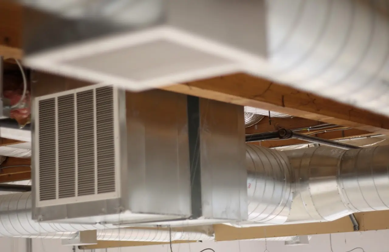 Ceiling-mounted HVAC unit and spiral ductwork detail on a commercial install