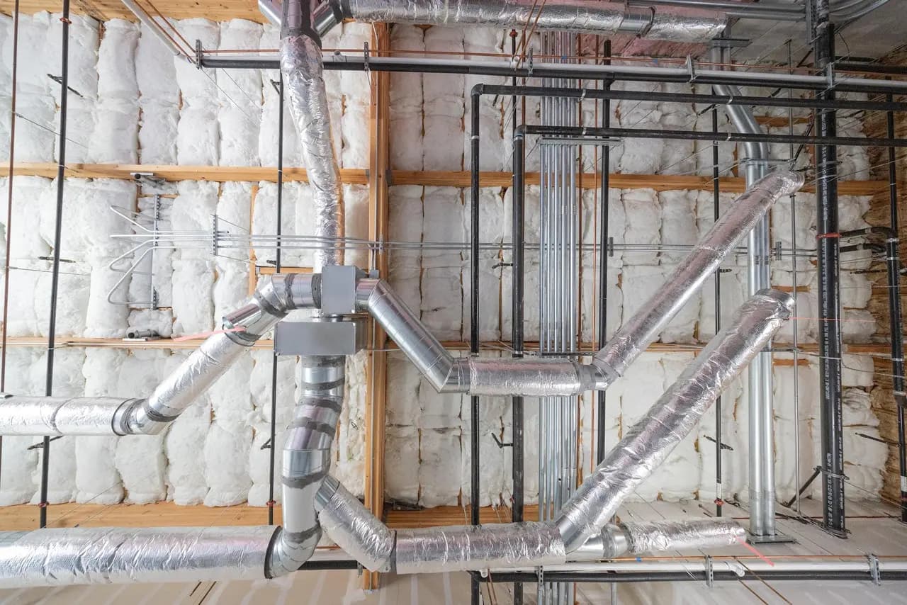 Insulated HVAC ductwork routed through a framed ceiling cavity