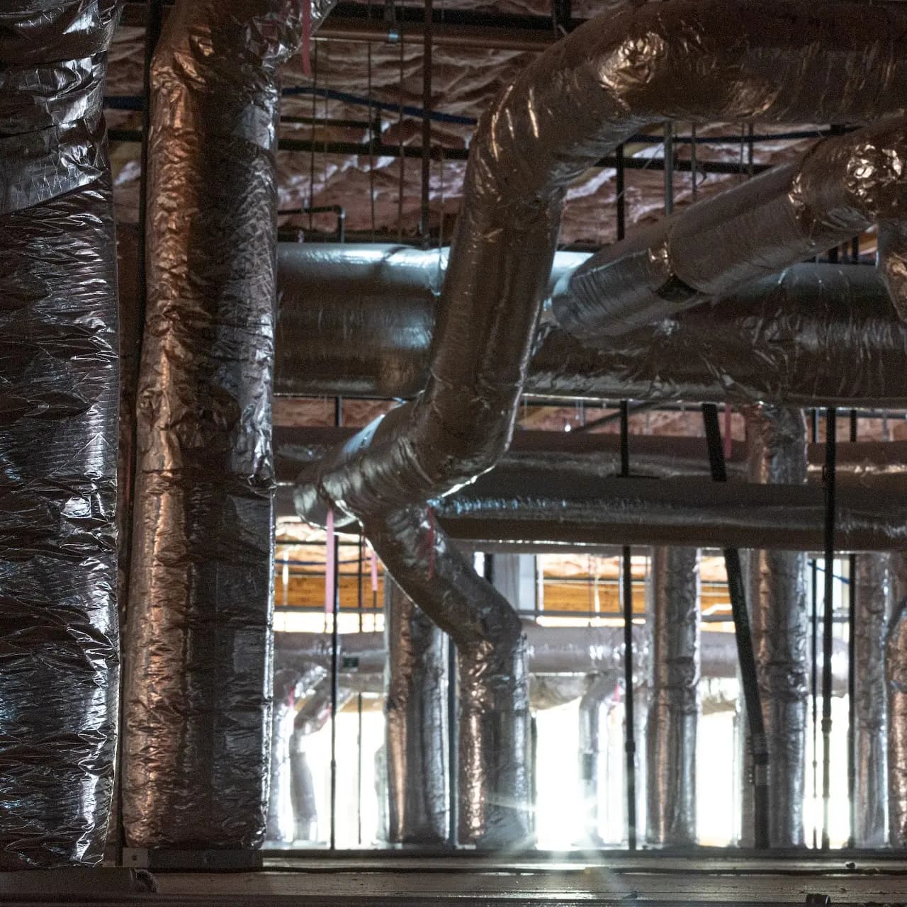 Insulated HVAC ductwork running through a Bay Area commercial building under construction