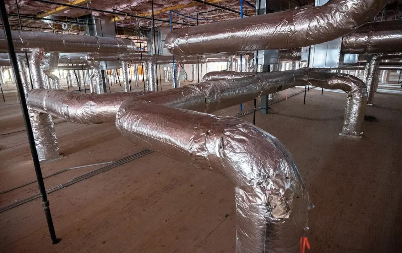 Large insulated round HVAC ductwork during a Bay Area commercial building fit-out